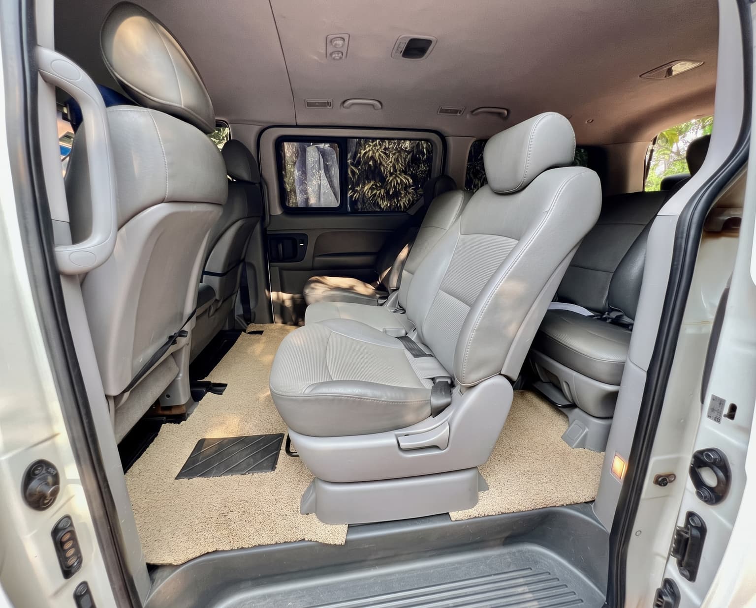 Amplios asientos VIP de cuero gris con mucho espacio en el Hyundai Starex de SafeRoam Express